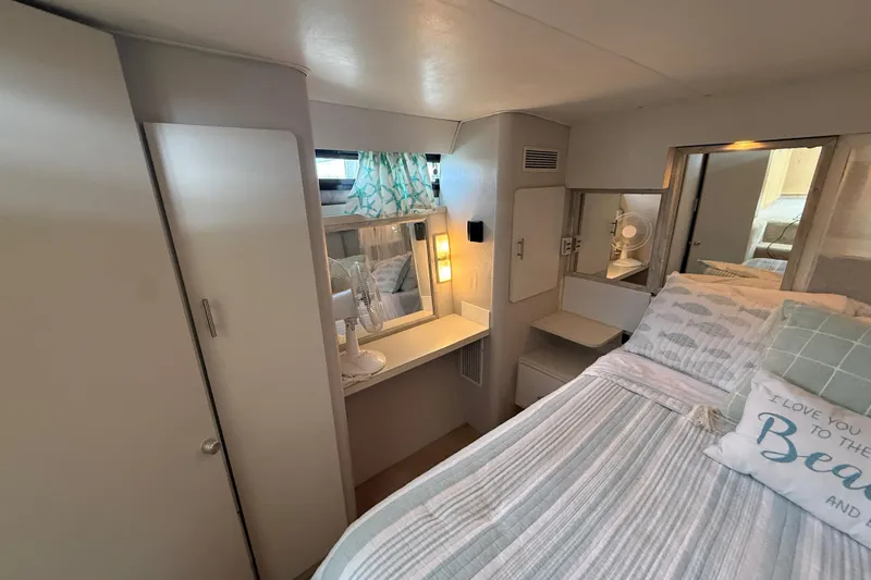 Slide: The Image of Interior of 1992 Silverton 41 Motor Yacht bedroom with cozy bed and vanity area. - 43