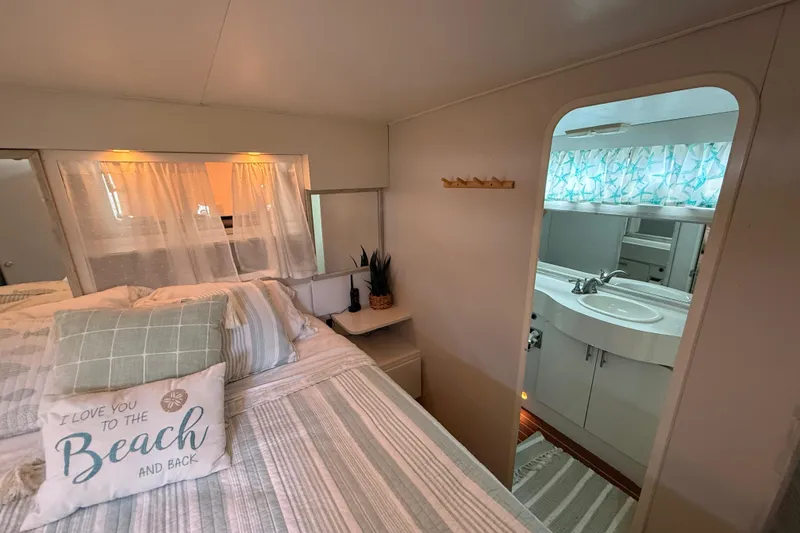 Slide: The Image of Bedroom and bathroom interior of 1992 Silverton 41 Motor Yacht, featuring cozy decor and nautical theme. - 44