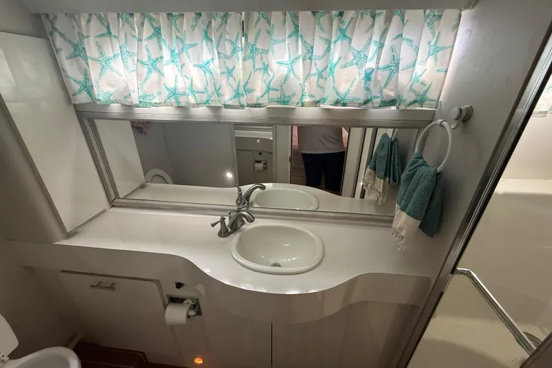 Slide: The Image of Bathroom interior of 1992 Silverton 41 Motor Yacht with starfish curtains and dual sinks. - 45