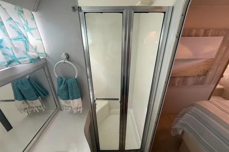 Slide: The Image of Bathroom interior of a 1992 Silverton 41 Motor Yacht with shower and teal accents. - 47