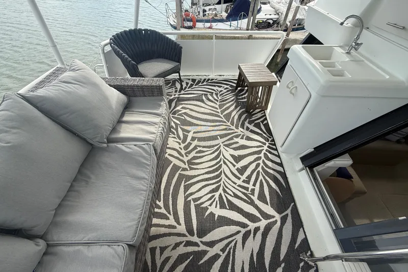Slide: The Image of 1992 Silverton 41 Motor Yacht deck with seating, patterned rug, and sink area. - 5