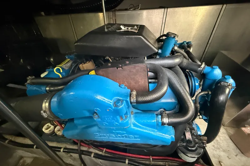 Slide: The Image of Engine of a 1992 Silverton 41 Motor Yacht, featuring blue components and hoses. - 52