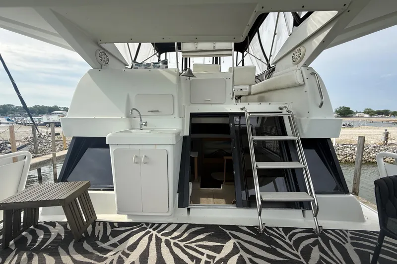 Slide: The Image of 1992 Silverton 41 Motor Yacht with outdoor sink, ladder, and patterned deck mat. - 6