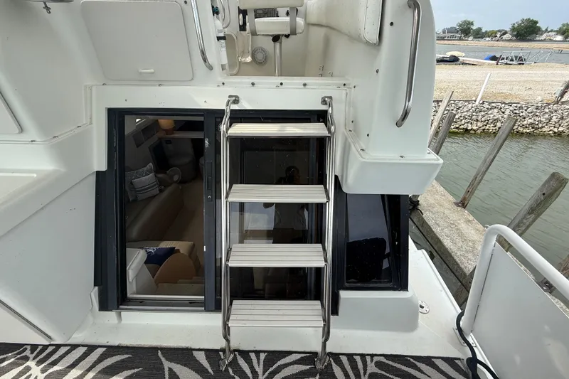 Slide: The Image of 1992 Silverton 41 Motor Yacht interior view with ladder and waterfront backdrop. - 8