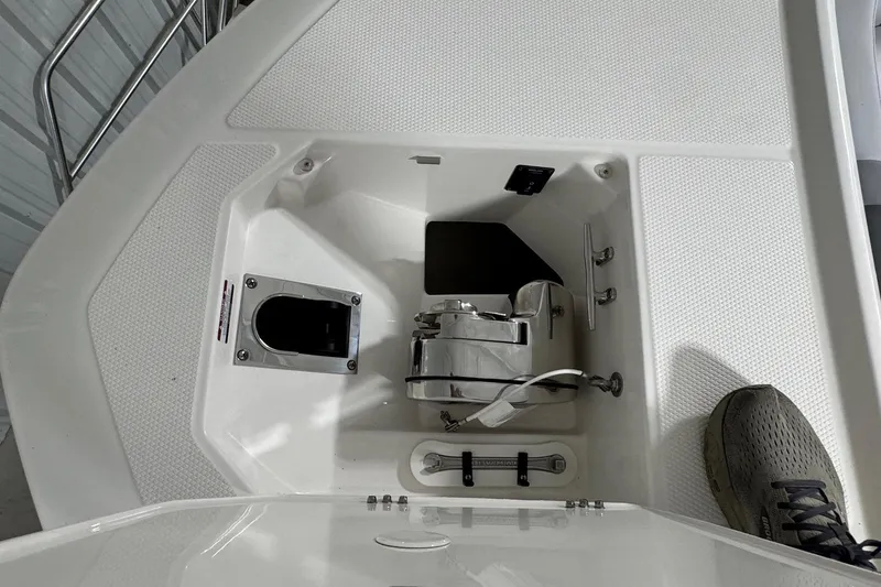 Slide: The Image of 2026 Robalo R300 Center Console anchor compartment with stainless steel fittings and textured deck. - 18