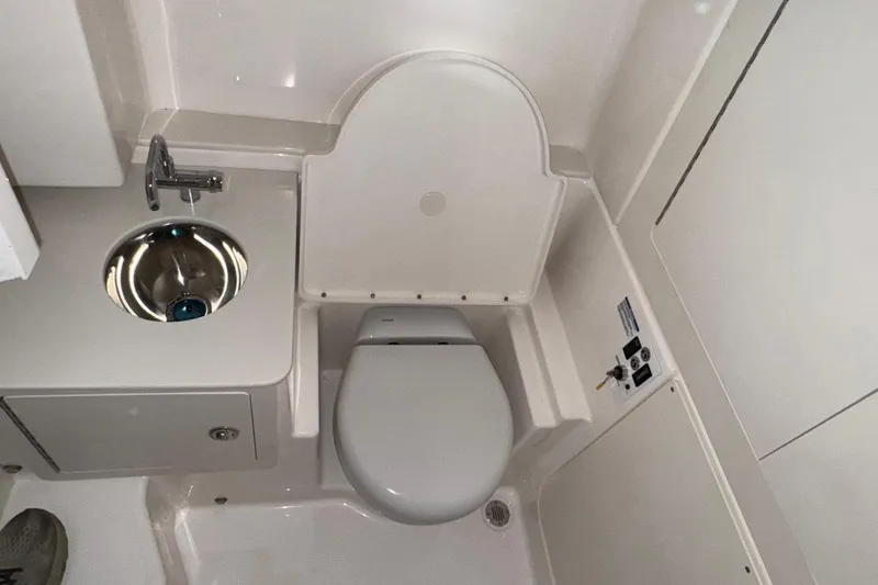 Slide: The Image of 2026 Robalo R300 Center Console boat bathroom with sink and toilet. - 20