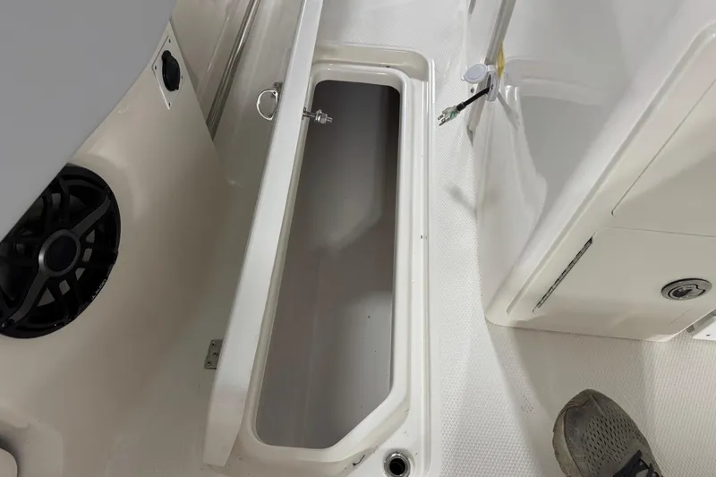 Slide: The Image of 2026 Robalo R300 Center Console boat storage compartment with speaker and wiring. - 23