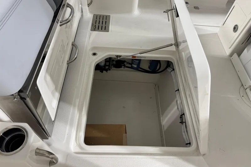 Slide: The Image of 2026 Robalo R300 Center Console boat storage compartment open, showcasing interior space. - 24