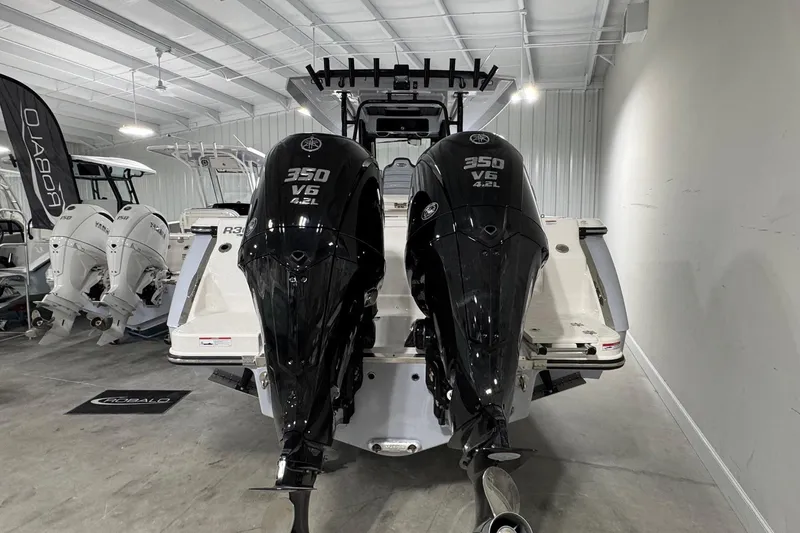 Slide: The Image of 2026 Robalo R300 Center Console with dual 350 V6 engines in a showroom. - 3