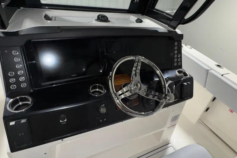 Slide: The Image of 2026 Robalo R300 Center Console boat dashboard with modern steering and controls. - 6