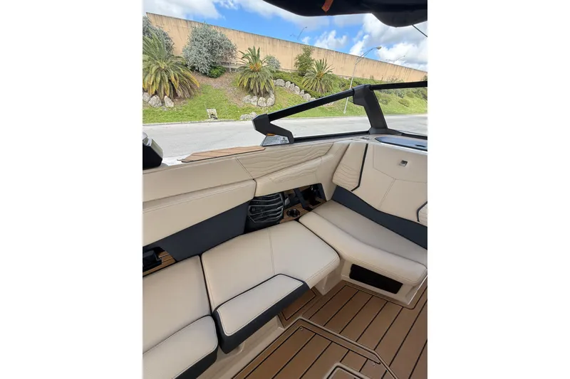 Slide: The Image of Interior of 2026 Nautique Super Air Nautique G25 Coastal Edition boat, featuring beige seating. - 11