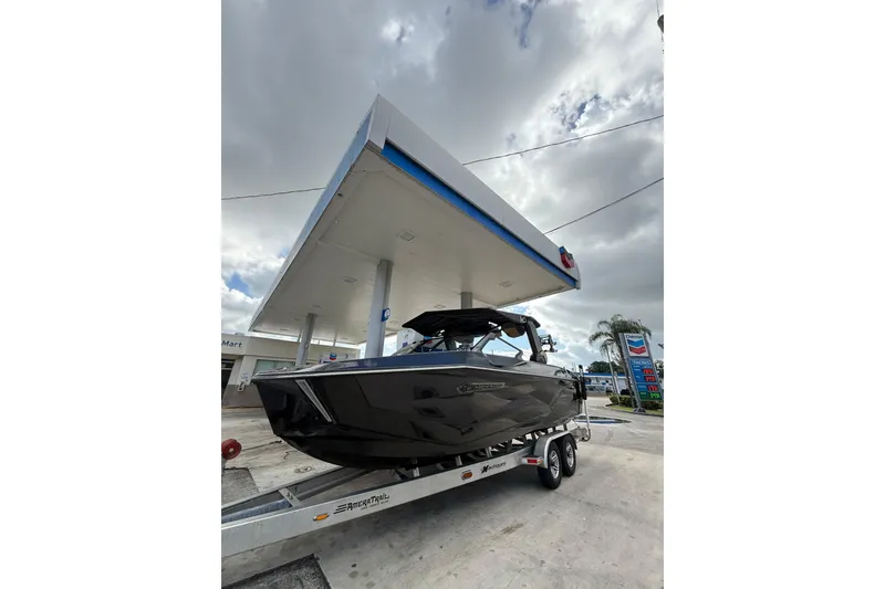 Slide: The Image of 2026 Nautique Super Air Nautique G25 Coastal Edition on trailer at gas station. - 2