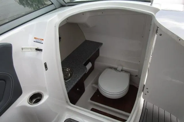 Slide: The Image of 2016 Chaparral 264 Sunesta boat interior with compact bathroom and sink. - 10