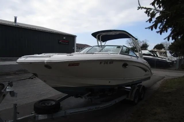 Slide: The Image of 2016 Chaparral 264 Sunesta boat on trailer, parked outdoors near a building. - 3