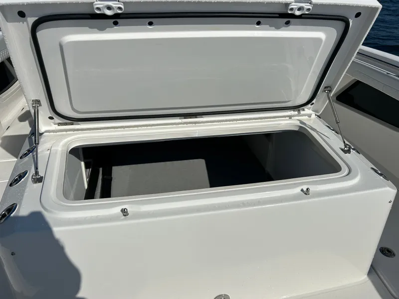 Slide: The Image of An open storage compartment on a 2027 Aquila A36MC boat, featuring sturdy hinges. - 28