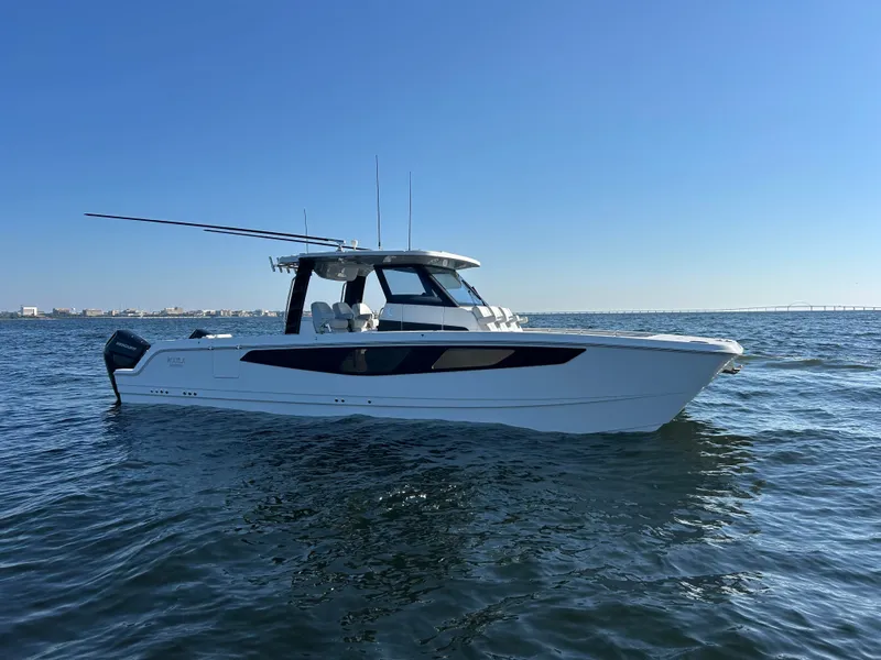 Slide: The Image of A modern Aquila A36MC boat from 2027 on calm water with a clear sky in the background. - 4