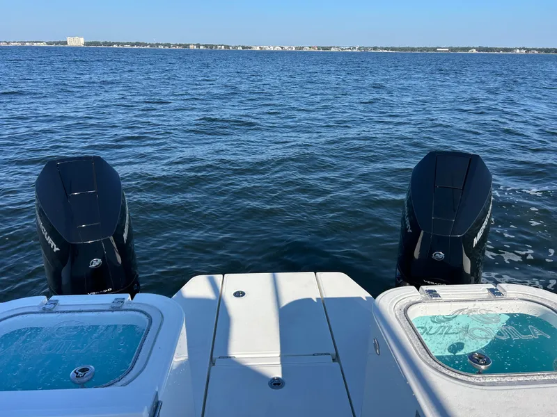 Slide: The Image of The image shows the stern of an Aquila A36MC with two outboard engines on calm water. - 8