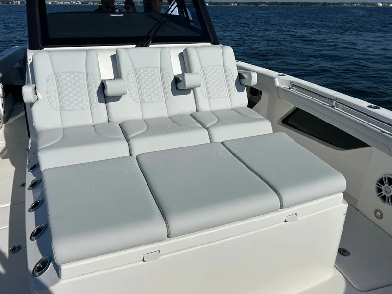 Slide: The Image of The 2027 Aquila A36MC features a spacious sun deck with cushioned seating on the water. - 26