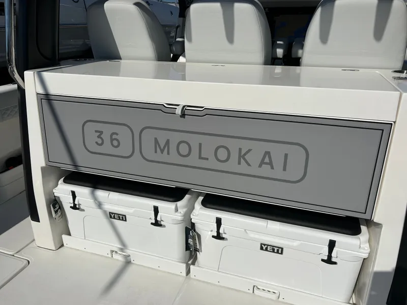 Slide: The Image of The image shows the storage area of an Aquila A36MC boat with two Yeti coolers underneath. - 21