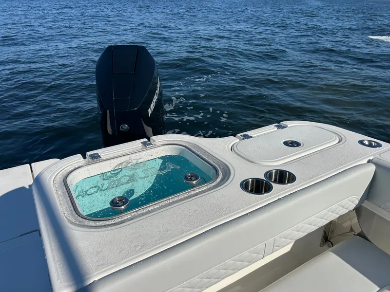 Slide: The Image of The image shows the stern of an Aquila A36MC boat with an outboard motor and a water basin. - 9