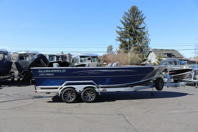 The Image of 2026 Alumaweld Columbia 21 boat on trailer, parked outdoors under clear sky. - 1