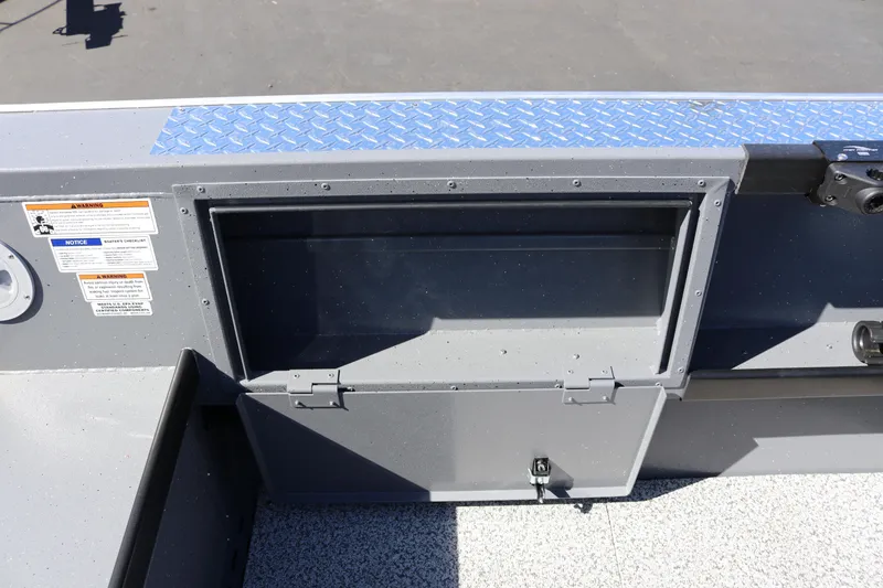 Slide: The Image of 2026 Alumaweld Columbia 21 boat storage compartment with safety warnings and diamond plate detail. - 24
