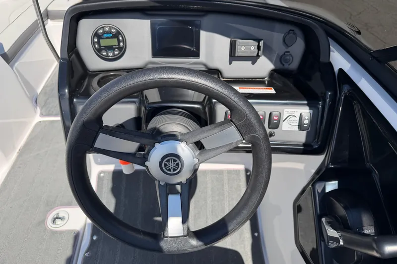 Slide: The Image of 2023 Yamaha Boats SX190 steering wheel and dashboard controls. - 10