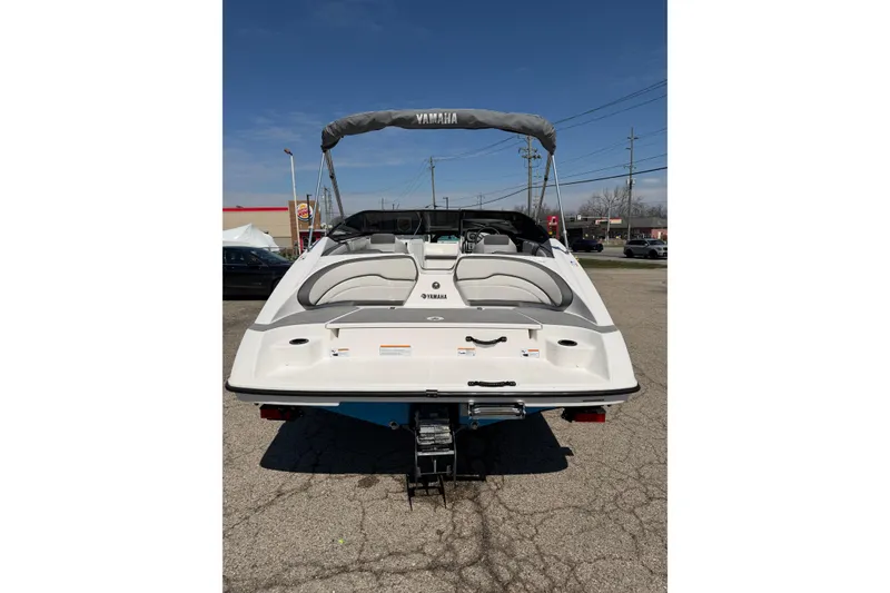 Slide: The Image of 2023 Yamaha Boats SX190, rear view, parked outdoors on a sunny day. - 2