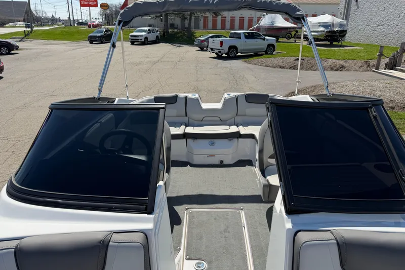 Slide: The Image of 2023 Yamaha Boats SX190 interior with seating and windshield, parked outdoors. - 6