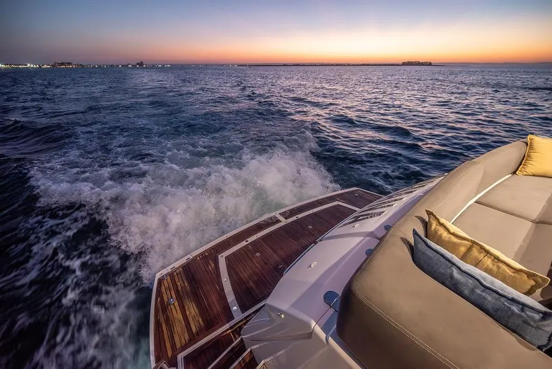 Slide: The Image of Luxurious 2012 Sunseeker Manhattan 73 yacht cruising at sunset, with elegant deck seating. - 21