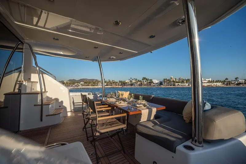 Slide: The Image of Luxurious Sunseeker Manhattan 73 yacht deck with elegant dining setup, overlooking serene waters. - 22