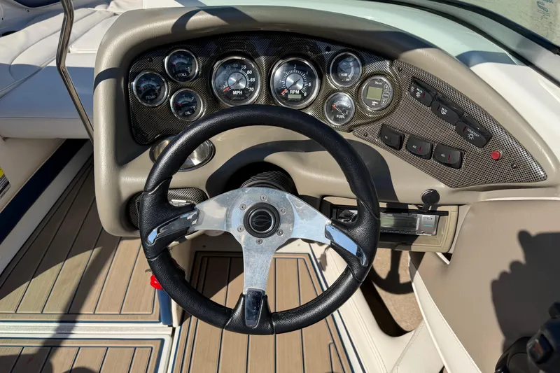 Slide: The Image of Steering wheel and dashboard of 2011 Crownline 21 SS boat, featuring gauges and controls. - 11