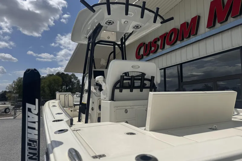 Slide: The Image of 2026 Pathfinder 2600 TRS boat at dealership, showcasing sleek design and spacious deck. - 13