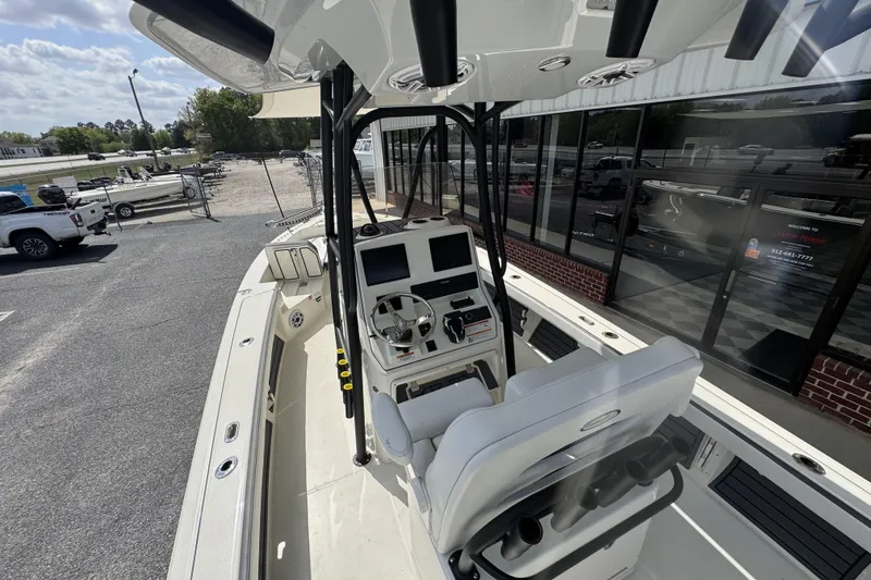 Slide: The Image of 2026 Pathfinder 2600 TRS boat interior with modern console and seating, parked outdoors. - 22