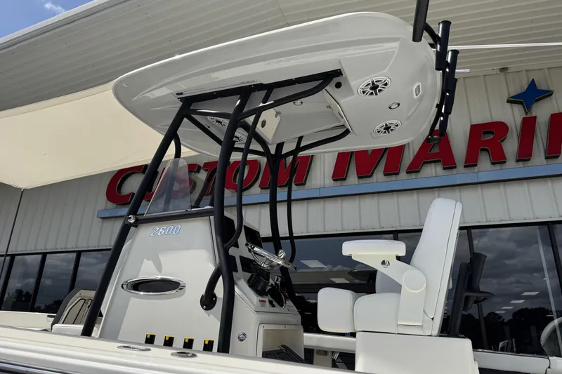 Slide: The Image of 2026 Pathfinder 2600 TRS boat at Custom Marine dealership, showcasing helm and seating. - 5