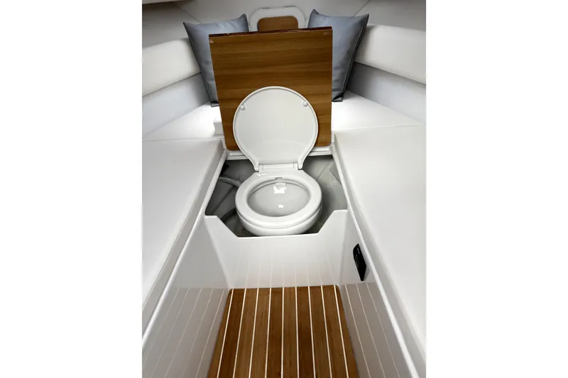 Slide: The Image of 2024 Comitti Venezia V28 interior with open toilet, wooden flooring, and cushioned seating. - 12