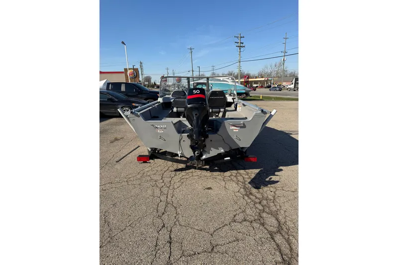 Slide: The Image of 2010 Tracker Pro Guide V-16 WT boat with outboard motor, parked on pavement. - 3
