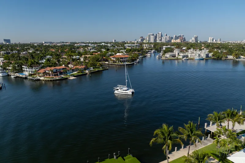 Slide: The Image of Aerial view of 2025 Fountaine Pajot FP41 Catamaran in a scenic waterfront setting. - 12