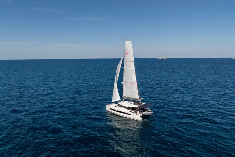 Slide: The Image of 2025 Fountaine Pajot FP41 Catamaran sailing on open sea under clear blue sky. - 15