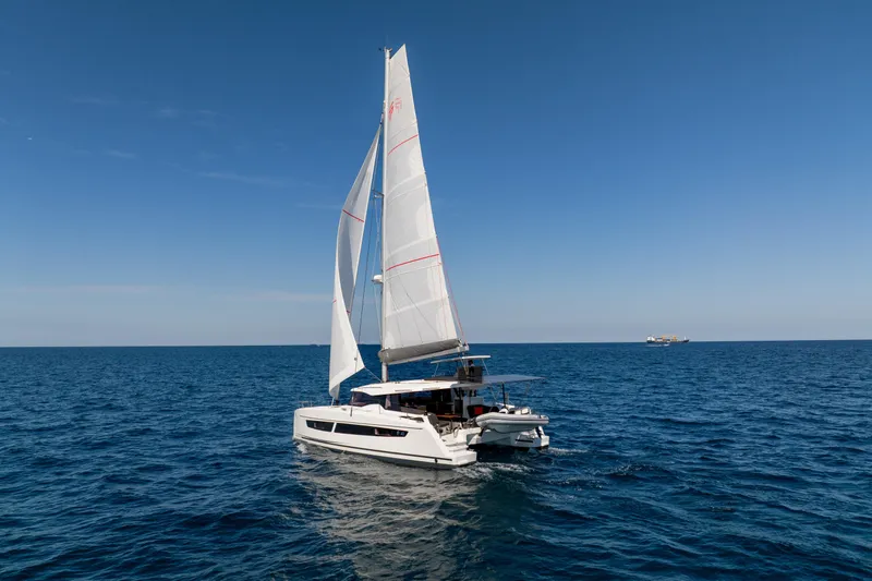 Slide: The Image of 2025 Fountaine Pajot FP41 Catamaran sailing on open sea under clear blue sky. - 16