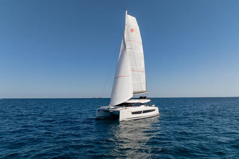 Slide: The Image of 2025 Fountaine Pajot FP41 Catamaran sailing on open sea under clear blue sky. - 17
