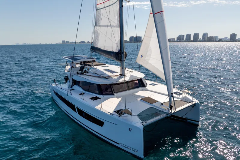 Slide: The Image of 2025 Fountaine Pajot FP41 Catamaran sailing on open water with city skyline in background. - 20