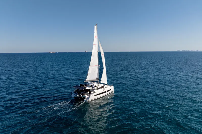 Slide: The Image of 2025 Fountaine Pajot FP41 Catamaran sailing on open sea under clear blue sky. - 24