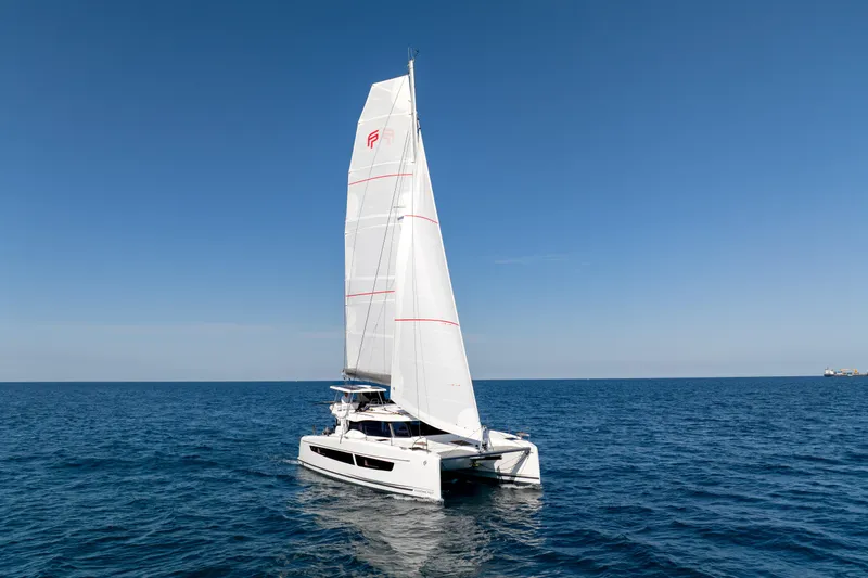 Slide: The Image of 2025 Fountaine Pajot FP41 Catamaran sailing on open sea under clear blue sky. - 26