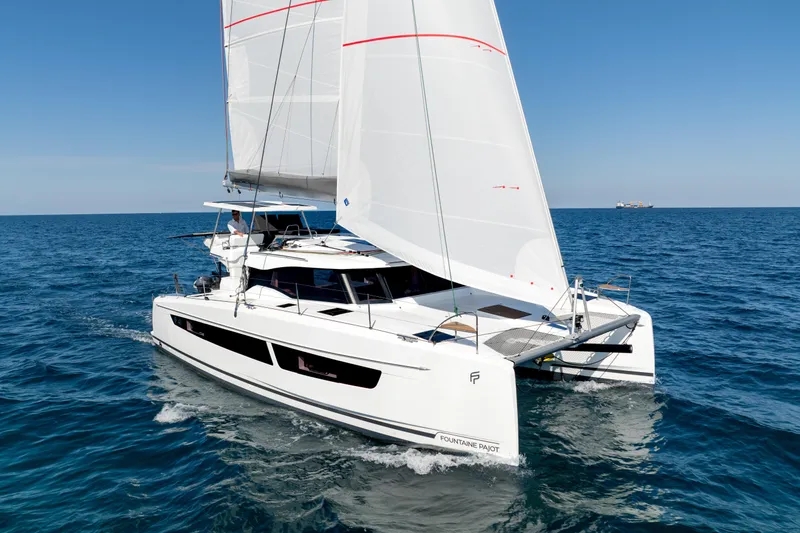 Slide: The Image of 2025 Fountaine Pajot FP41 Catamaran sailing on open sea under clear blue skies. - 27