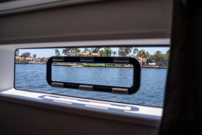 Slide: The Image of View from 2025 Fountaine Pajot FP41 Catamaran window overlooking waterfront homes and palm trees. - 42
