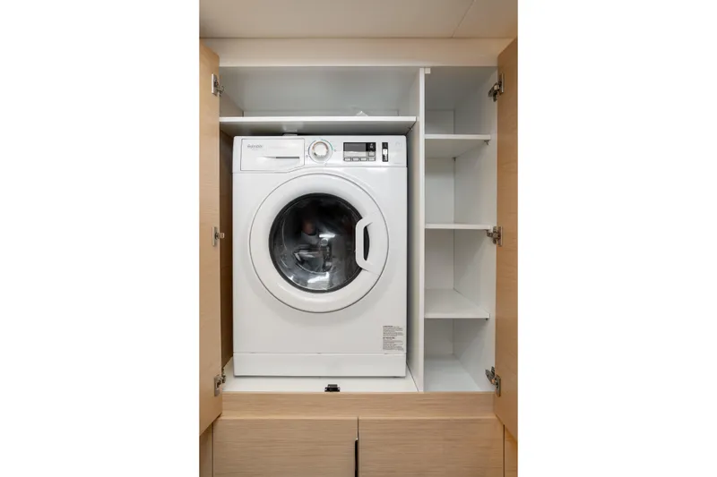 Slide: The Image of Washing machine in cabinet on 2025 Fountaine Pajot FP41 Catamaran, with adjacent shelving. - 47