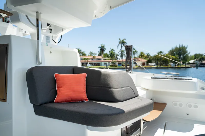 Slide: The Image of 2025 Fountaine Pajot FP41 Catamaran interior with gray seating and orange cushion. - 61