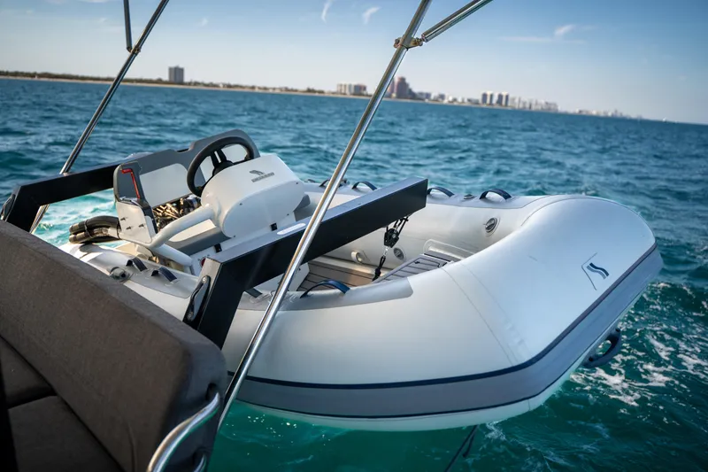 Slide: The Image of 2025 Fountaine Pajot FP41 Catamaran with inflatable boat on ocean, city skyline in background. - 70