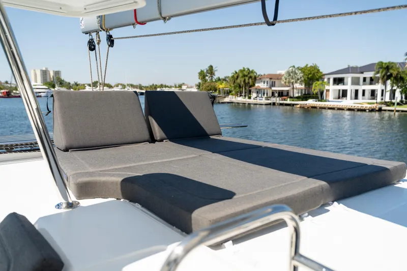 Slide: The Image of Luxurious sunbathing area on 2025 Fountaine Pajot New 41 catamaran, overlooking serene waterfront homes. - 74